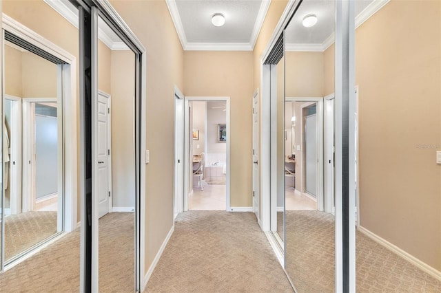 hallway featuring crown molding and light carpet