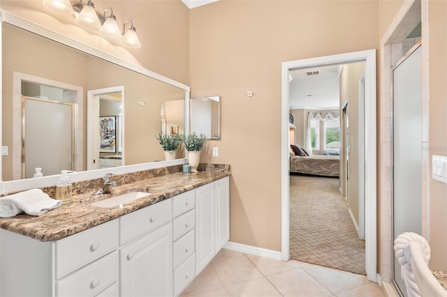 bathroom featuring vanity, a shower with shower door, and tile patterned floors