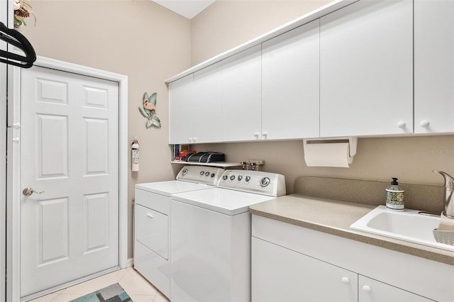 laundry room featuring light tile patterned flooring, cabinets, washer and clothes dryer, and sink