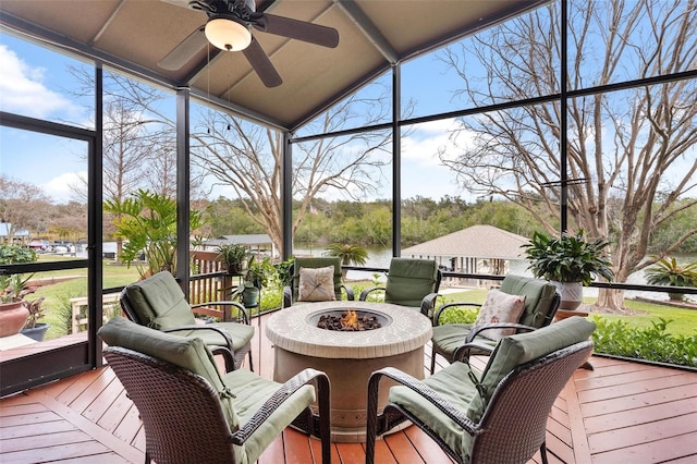 sunroom featuring a water view and ceiling fan