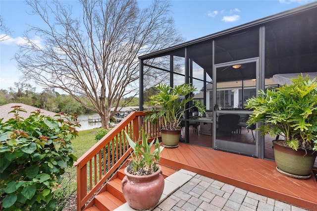 wooden deck featuring a sunroom and a water view