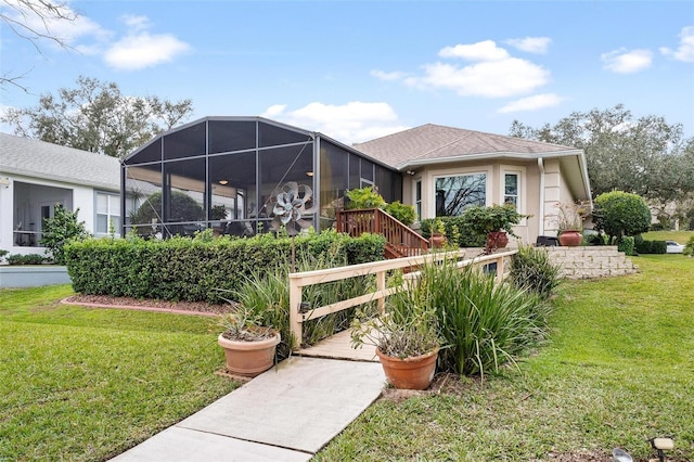 view of front facade featuring glass enclosure and a front yard