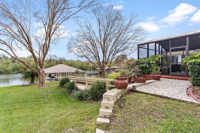 view of yard with a sunroom and a water view