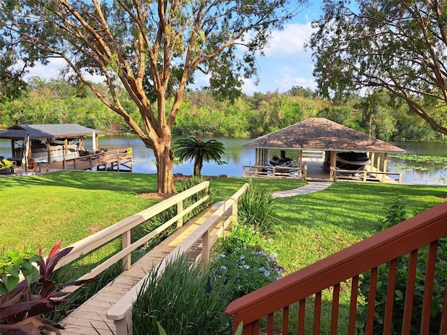 view of yard with boat lift, a dock, and a water view