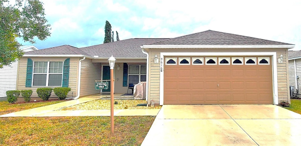 view of front of house with a front lawn, a garage, and a porch