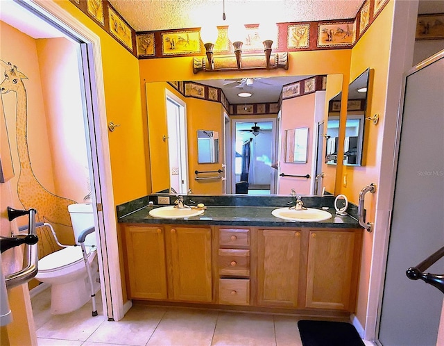 bathroom with tile patterned flooring, vanity, a textured ceiling, and toilet