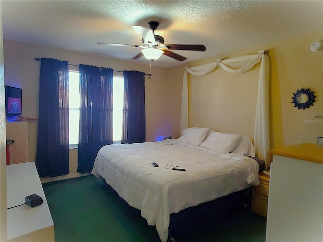 bedroom with ceiling fan and a textured ceiling