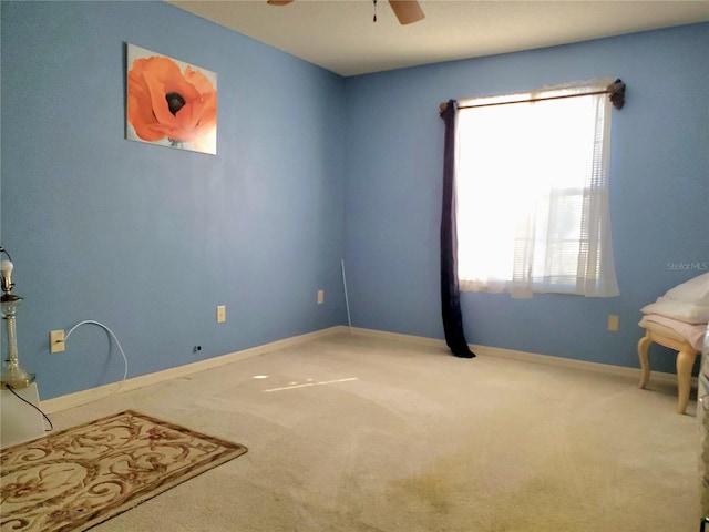 empty room featuring carpet floors, a healthy amount of sunlight, and ceiling fan