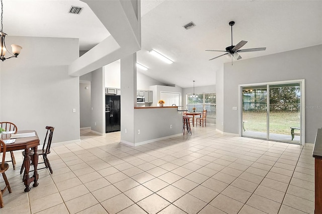 kitchen featuring light tile patterned flooring, ceiling fan with notable chandelier, black refrigerator with ice dispenser, and lofted ceiling