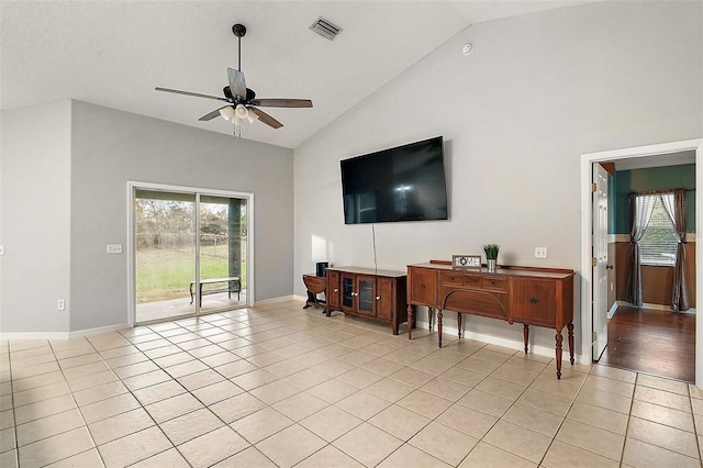 tiled living room featuring ceiling fan and high vaulted ceiling