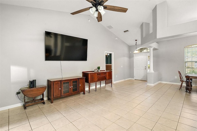 living room with decorative columns, ceiling fan, high vaulted ceiling, and light tile patterned floors