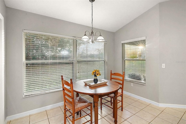 tiled dining space with a healthy amount of sunlight, a chandelier, and vaulted ceiling