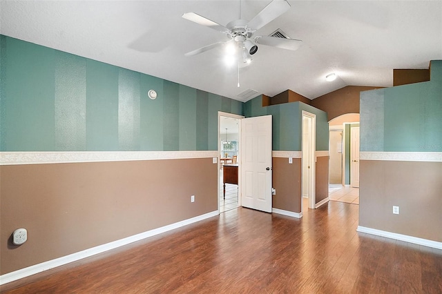 empty room featuring vaulted ceiling, ceiling fan, and hardwood / wood-style flooring