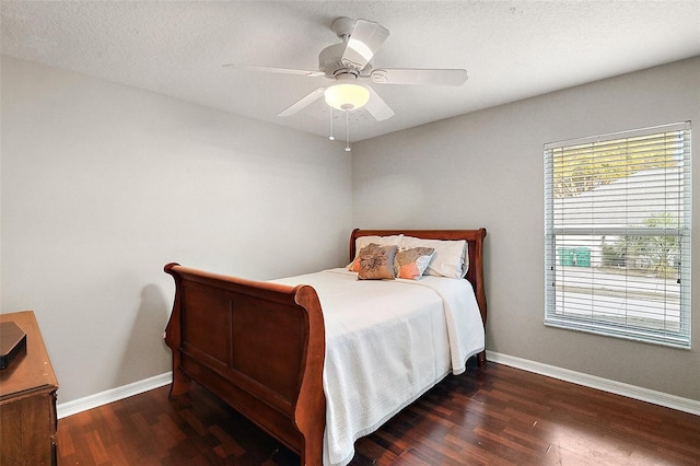 bedroom with dark wood-type flooring, a textured ceiling, and ceiling fan