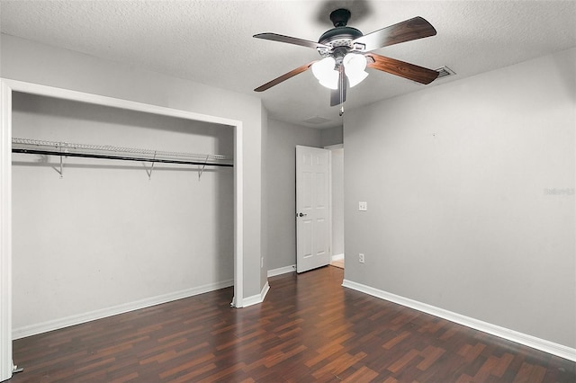 unfurnished bedroom featuring a closet, ceiling fan, dark wood-type flooring, and a textured ceiling