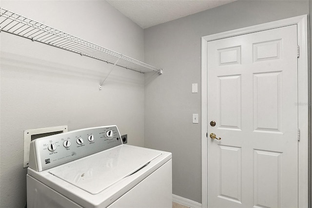 washroom with a textured ceiling and washer / clothes dryer