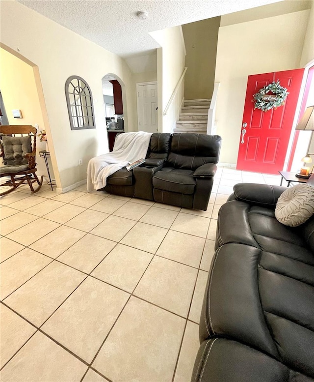 tiled living room featuring a textured ceiling