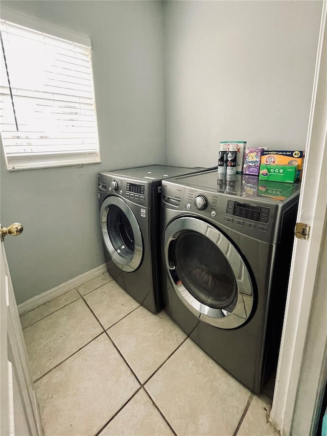 laundry area featuring light tile patterned floors and washing machine and dryer