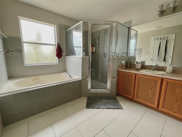 bathroom with tile patterned floors, vanity, and shower with separate bathtub