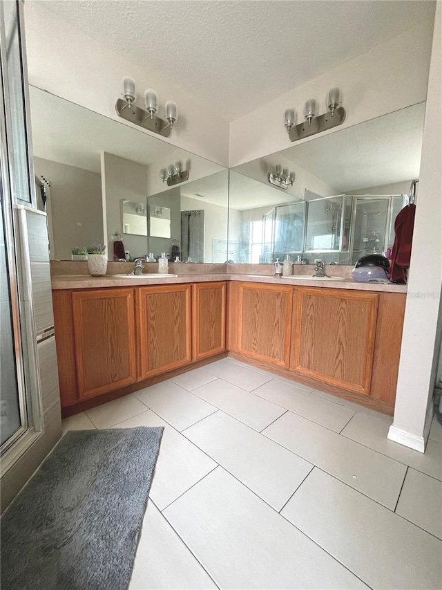 bathroom featuring tile patterned floors, walk in shower, vanity, and a textured ceiling