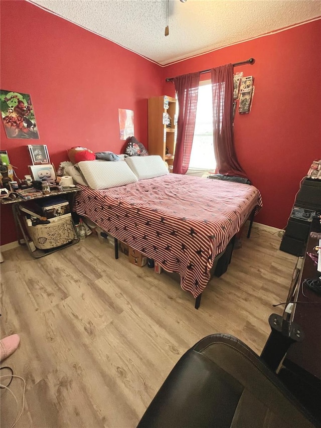 bedroom with a textured ceiling and wood-type flooring