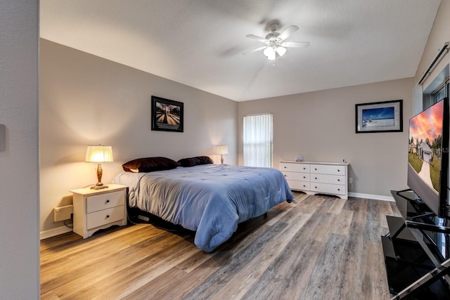 bedroom with wood-type flooring, a textured ceiling, and ceiling fan