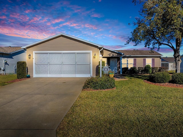 ranch-style house featuring a lawn and a garage