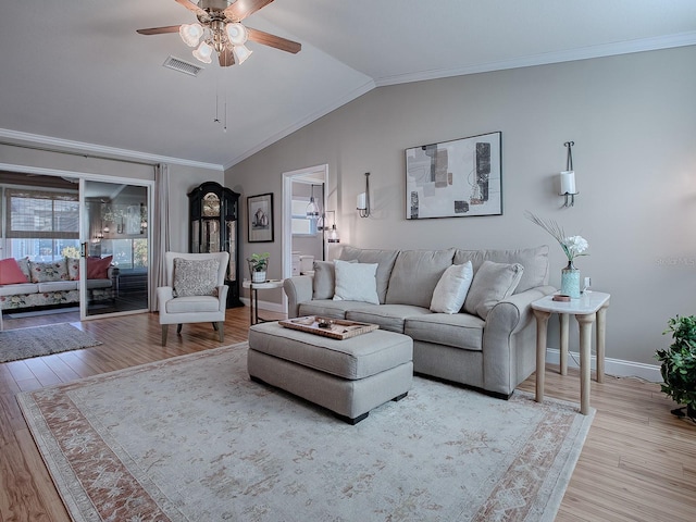 living room featuring vaulted ceiling, ornamental molding, and light hardwood / wood-style floors