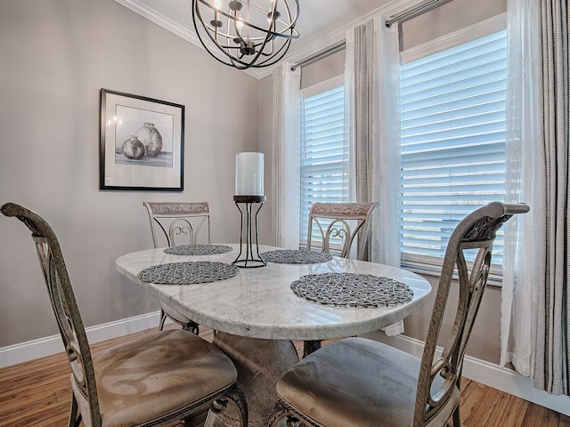 dining room featuring a healthy amount of sunlight, a notable chandelier, crown molding, and light hardwood / wood-style flooring