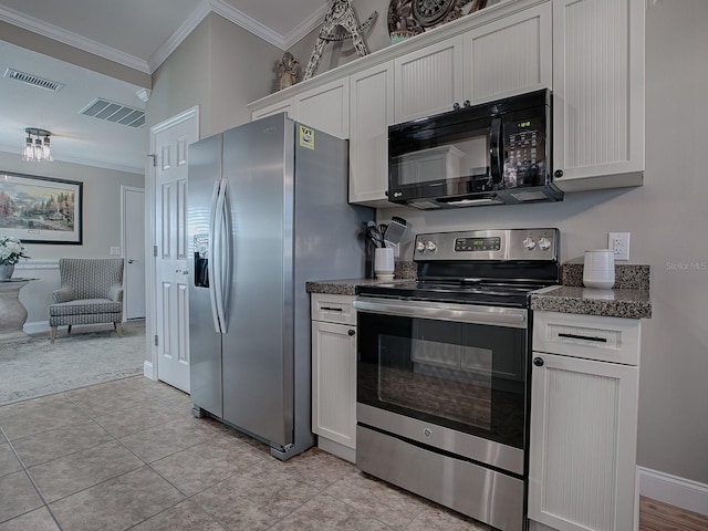 kitchen with light tile patterned floors, ornamental molding, stainless steel appliances, and white cabinetry