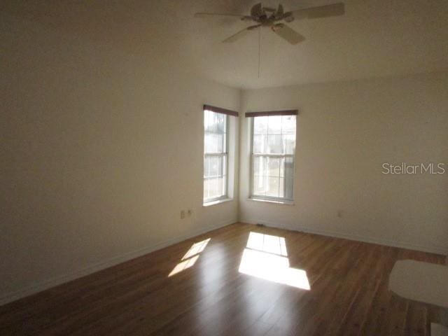 spare room featuring dark wood-type flooring and ceiling fan