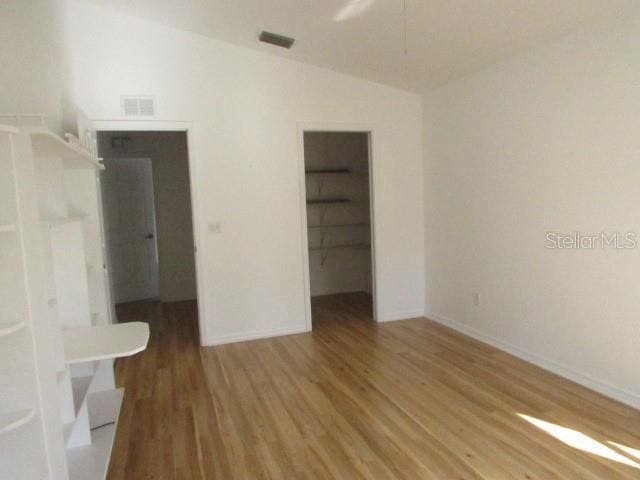 empty room featuring hardwood / wood-style floors and vaulted ceiling