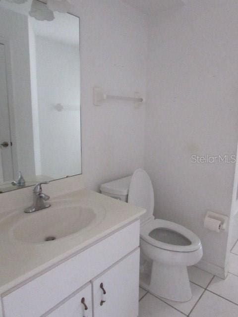 bathroom featuring tile patterned floors, vanity, and toilet