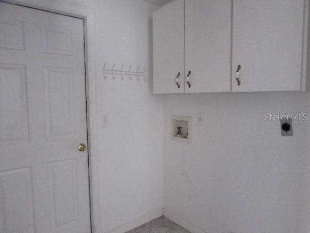 washroom with light tile patterned floors, washer hookup, electric dryer hookup, and cabinets