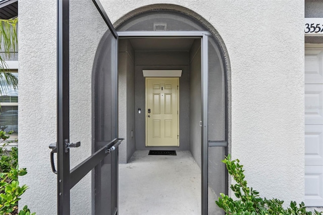 entrance to property featuring stucco siding