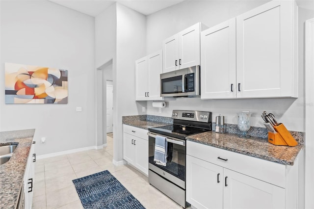 13557 Willow Bluestar Loop, Riverview, FL 33579 - kitchen featuring dark stone countertops, white cabinetry, and stainless steel appliances