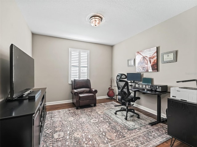 home office with dark wood-type flooring and a textured ceiling