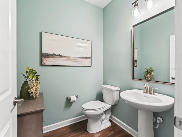 bathroom featuring wood-type flooring and toilet