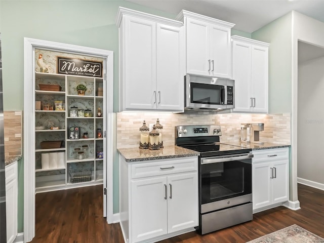 kitchen featuring white cabinetry, appliances with stainless steel finishes, dark wood-type flooring, and backsplash