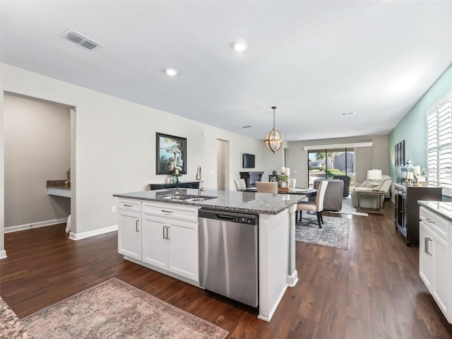 kitchen featuring an island with sink, sink, stainless steel dishwasher, and white cabinets