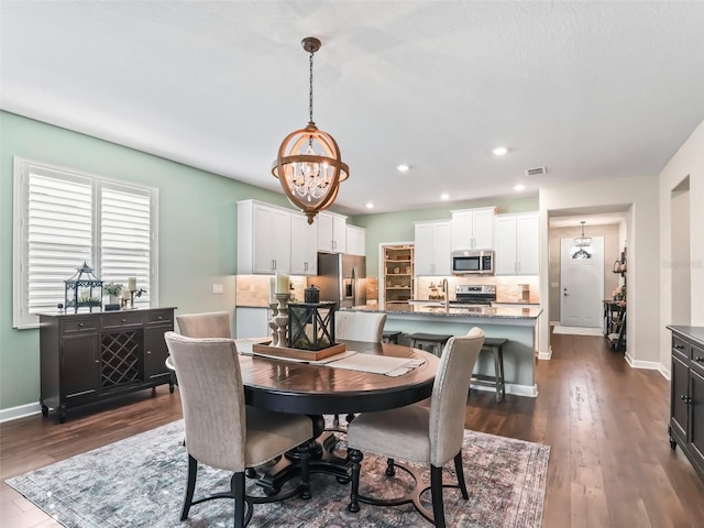 dining room with an inviting chandelier, dark hardwood / wood-style flooring, and sink