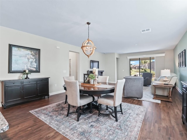 dining space featuring dark hardwood / wood-style floors and a chandelier