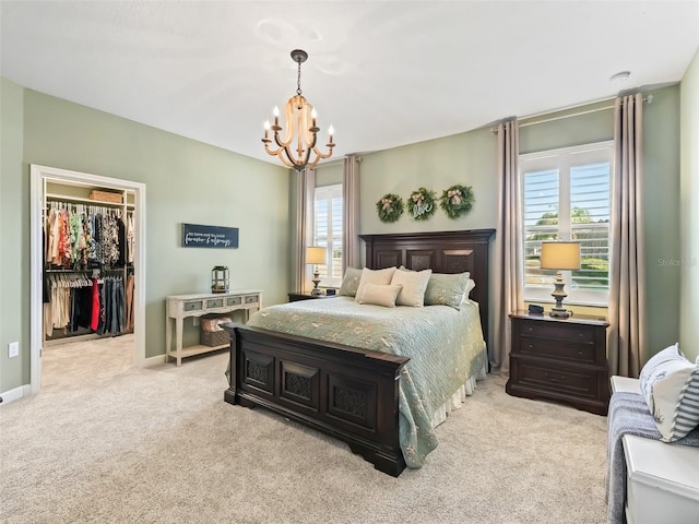 carpeted bedroom featuring a spacious closet, a closet, and a chandelier