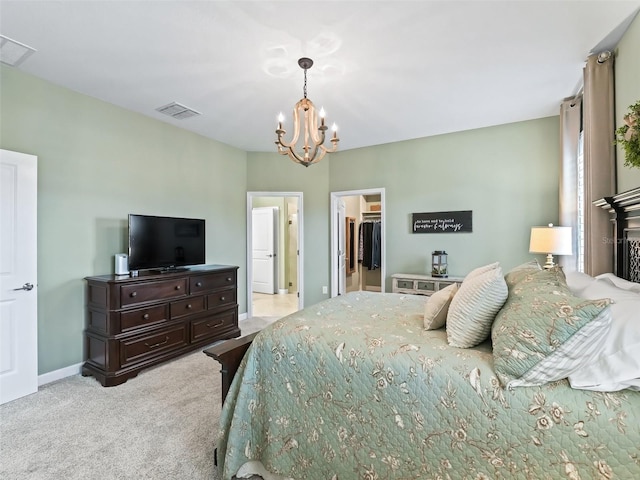 carpeted bedroom with a walk in closet, a chandelier, and a closet