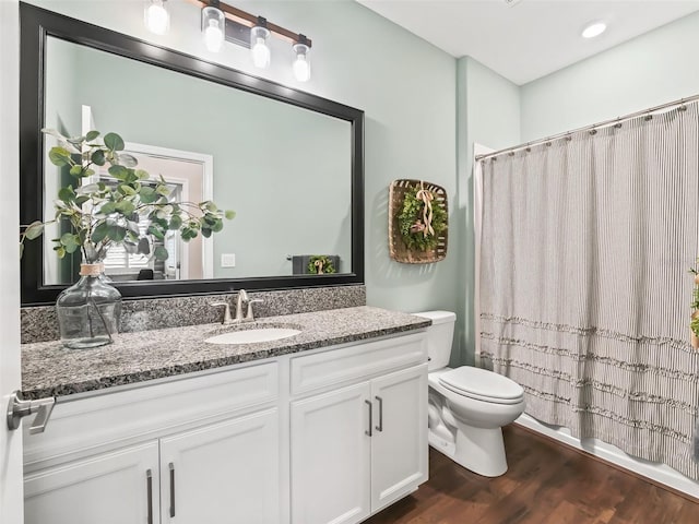 bathroom featuring vanity, hardwood / wood-style flooring, and toilet