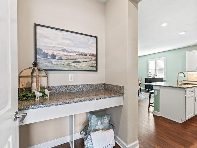 interior space with hardwood / wood-style flooring, sink, and built in desk