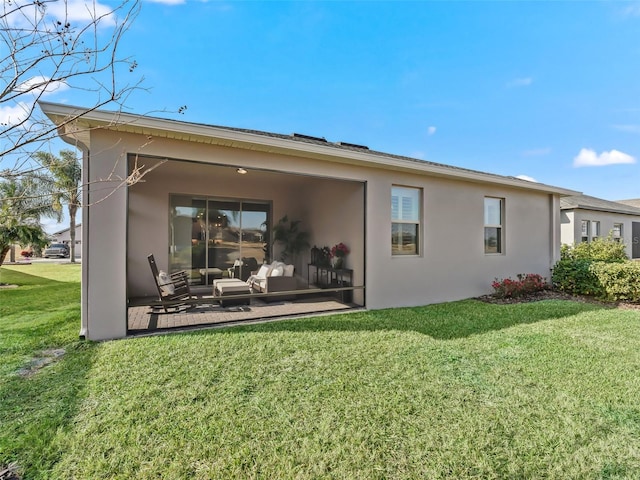 rear view of house featuring a lawn and a patio