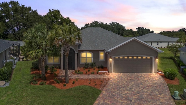 view of front of property with a garage and a lawn