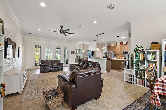 tiled living room featuring ceiling fan, crown molding, and french doors