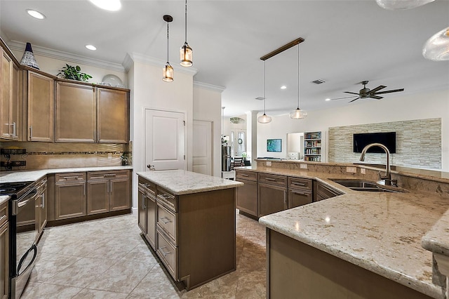 kitchen featuring ceiling fan, a kitchen island, pendant lighting, stainless steel electric range, and sink